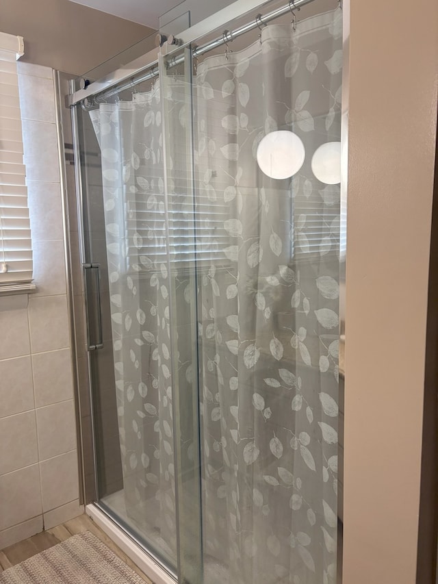 full bathroom with wood finished floors and a stall shower