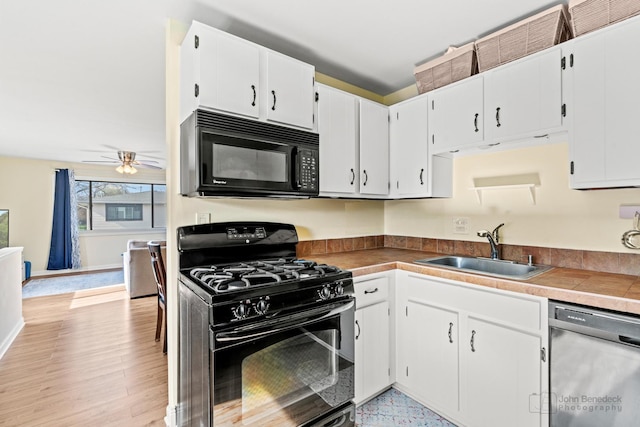 kitchen with a sink, white cabinets, a ceiling fan, and black appliances