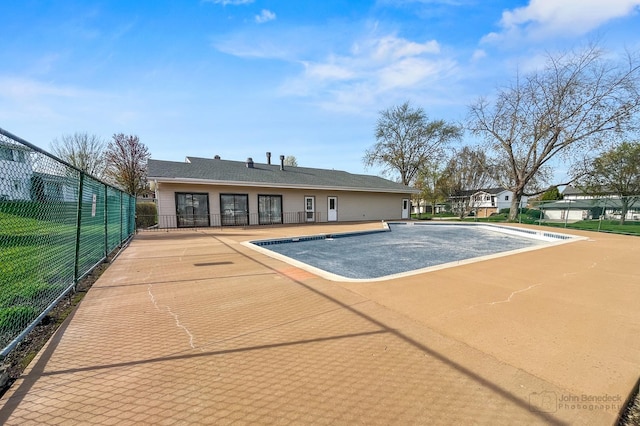 community pool with fence and a patio
