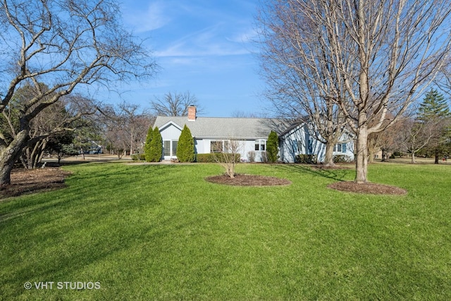 ranch-style home with a chimney and a front lawn