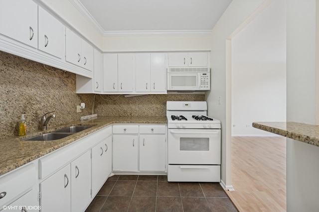 kitchen with a sink, crown molding, white appliances, and white cabinets