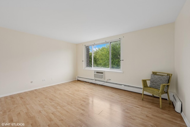 empty room with light wood-style floors, baseboards, a baseboard radiator, and a wall unit AC