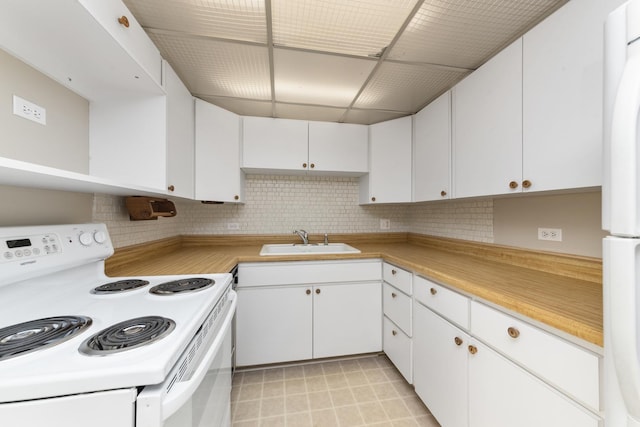 kitchen with white appliances, backsplash, a sink, and light countertops