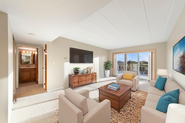 living area with baseboards and light colored carpet