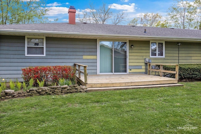 back of house with a yard, a chimney, and a wooden deck
