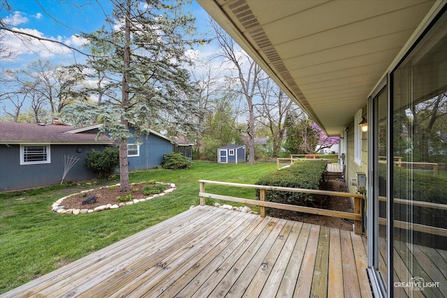 wooden deck featuring a lawn, an outdoor structure, and a storage unit