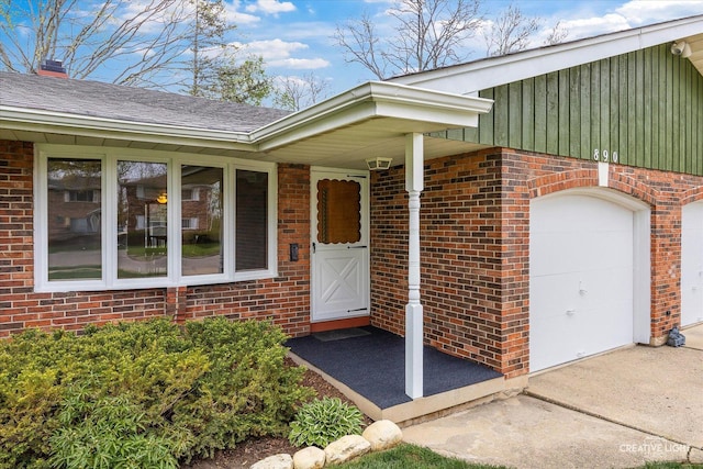 entrance to property with brick siding and a garage