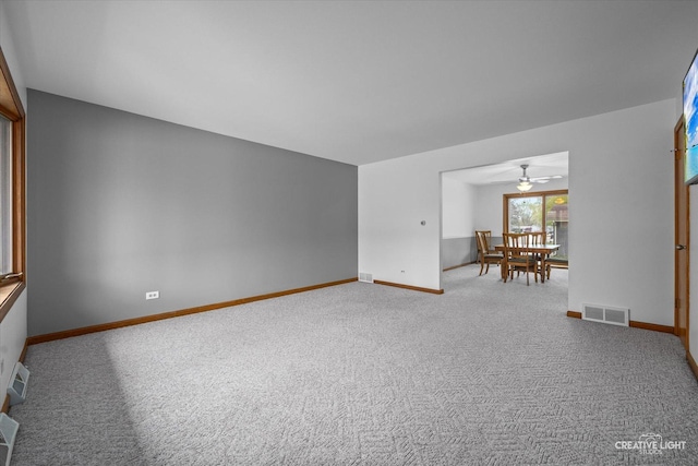 carpeted empty room featuring a ceiling fan, baseboards, and visible vents