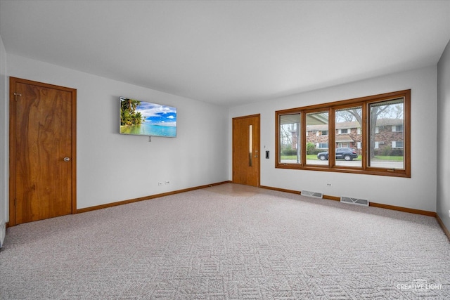 empty room with baseboards, carpet flooring, and visible vents