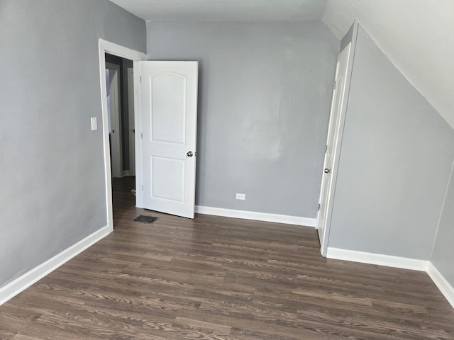 interior space featuring visible vents, baseboards, and dark wood-style floors