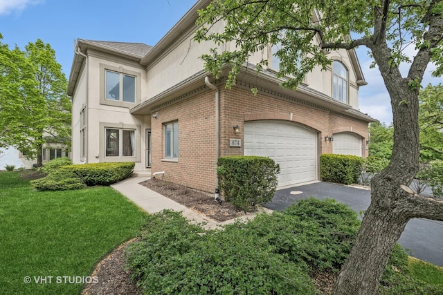 874 W Goodrich Pl, Palatine, IL 60067 - view of home's exterior featuring brick siding, driveway, a garage, a lawn, and stucco siding