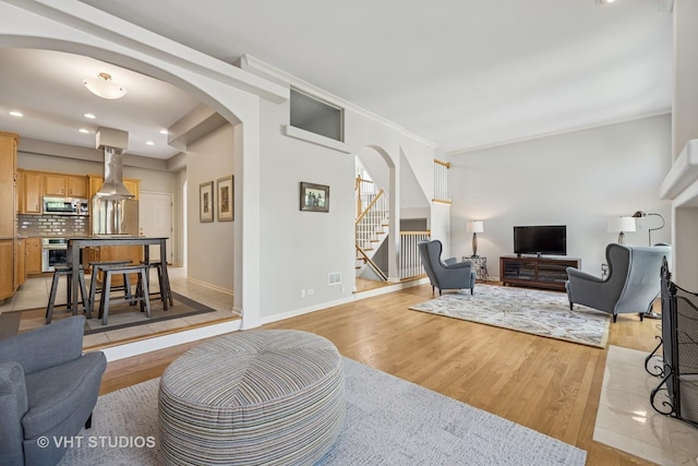 874 W Goodrich Pl, Palatine, IL 60067 - living room with arched walkways, light wood-type flooring, stairs, baseboards, and recessed lighting