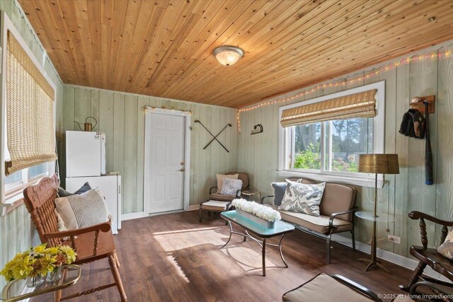 sitting room with wooden walls, baseboards, wood ceiling, and wood finished floors