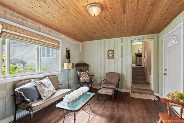 living area featuring wood finished floors, wooden ceiling, and stairway