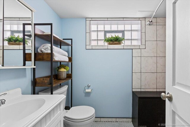 bathroom with vanity, tile patterned flooring, toilet, and a wealth of natural light