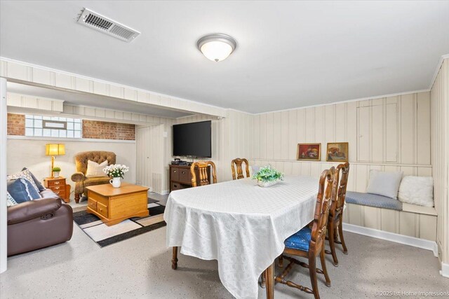 dining room featuring visible vents, ornamental molding, and a decorative wall
