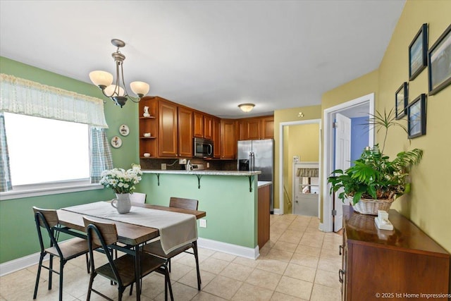dining area with light tile patterned floors, baseboards, and a chandelier