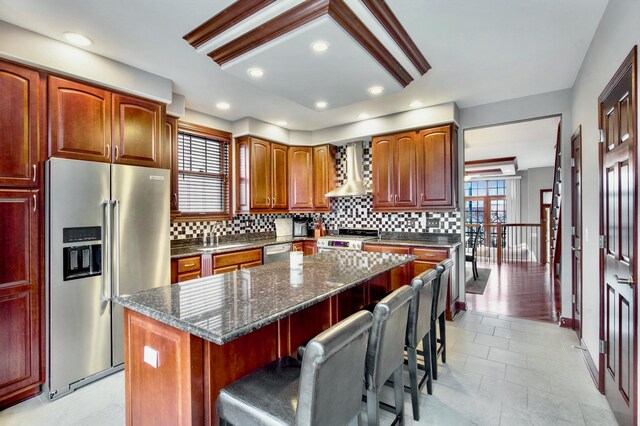 5912 N NW Hwy, Chicago, IL 60631 - kitchen featuring stainless steel appliances, wall chimney exhaust hood, decorative backsplash, a sink, and a breakfast bar area