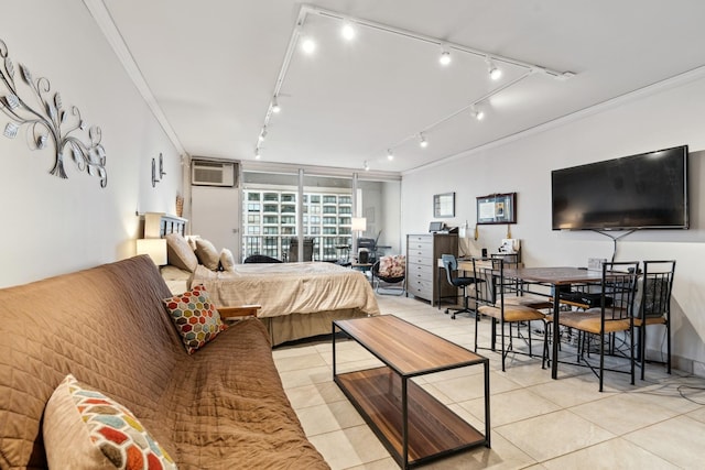 bedroom featuring an AC wall unit, rail lighting, light tile patterned flooring, and ornamental molding
