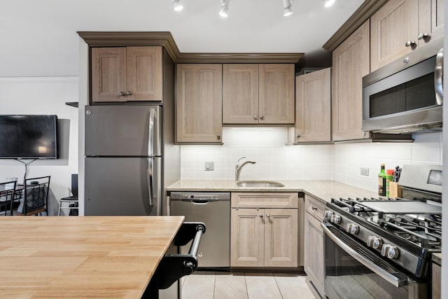 kitchen with decorative backsplash, light tile patterned flooring, light stone counters, a sink, and stainless steel appliances