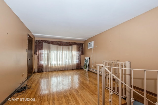 6004 S Kolmar Ave, Chicago, IL 60629 - spare room with baseboards, a baseboard radiator, an AC wall unit, and wood finished floors