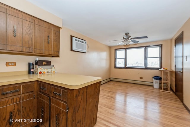 6004 S Kolmar Ave, Chicago, IL 60629 - kitchen with a ceiling fan, light countertops, a baseboard radiator, a peninsula, and light wood-style floors