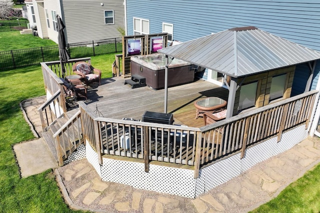 wooden deck with a lawn, a fenced backyard, and a hot tub