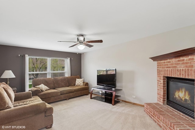 living area with baseboards, ceiling fan, a brick fireplace, and light colored carpet