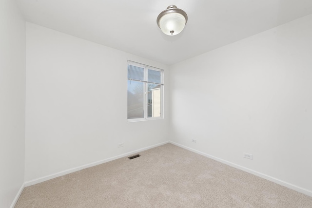 empty room with baseboards, carpet flooring, and visible vents