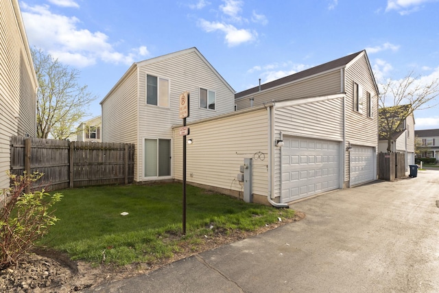 view of side of property with a yard, fence, and aphalt driveway