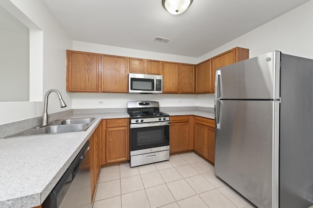 kitchen featuring visible vents, brown cabinets, a sink, light countertops, and stainless steel appliances