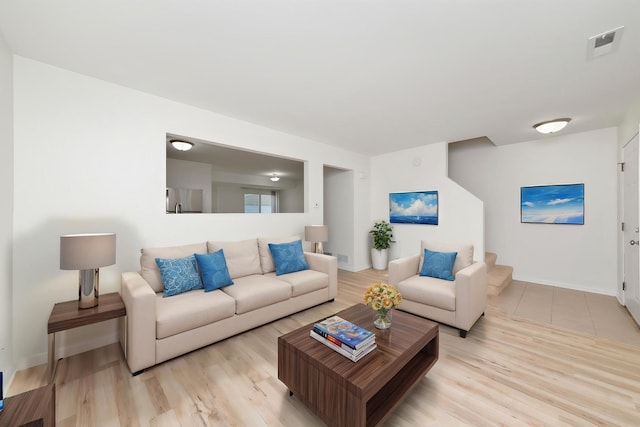 living area with baseboards, wood finished floors, and visible vents