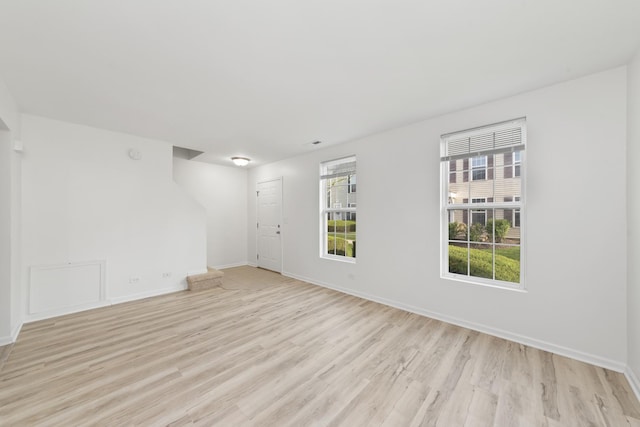 spare room featuring baseboards and light wood-style flooring