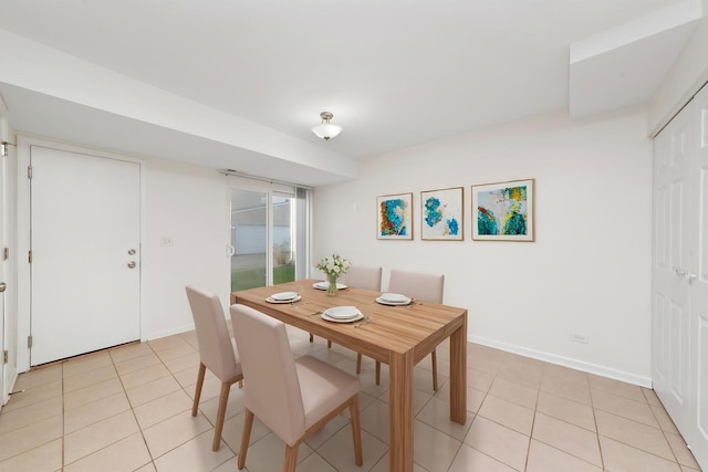 dining area featuring light tile patterned floors and baseboards