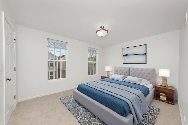 bedroom with baseboards and light carpet
