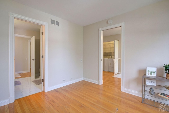 unfurnished bedroom featuring baseboards, light wood-type flooring, independent washer and dryer, and visible vents