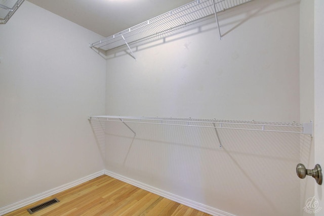spacious closet featuring wood finished floors and visible vents