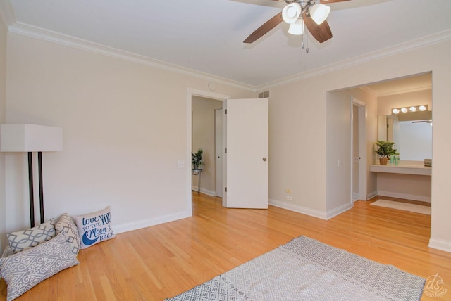 interior space featuring visible vents, ornamental molding, wood finished floors, baseboards, and ceiling fan