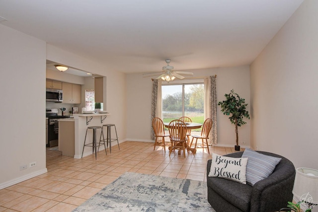 interior space featuring light tile patterned floors, baseboards, and ceiling fan