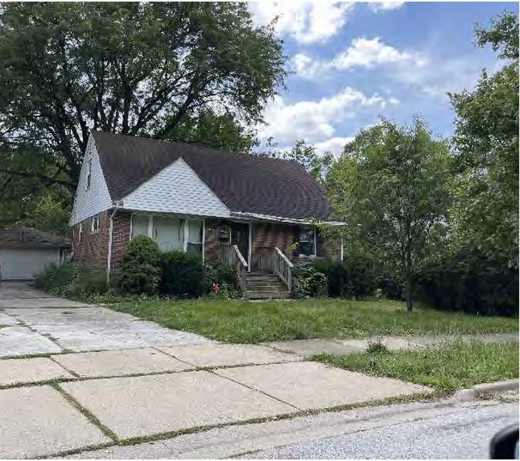 view of front facade featuring brick siding and a front yard