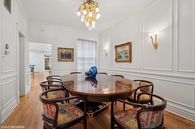2535 N Burling St, Chicago, IL 60614 - dining space with a decorative wall, a chandelier, crown molding, and light wood-type flooring
