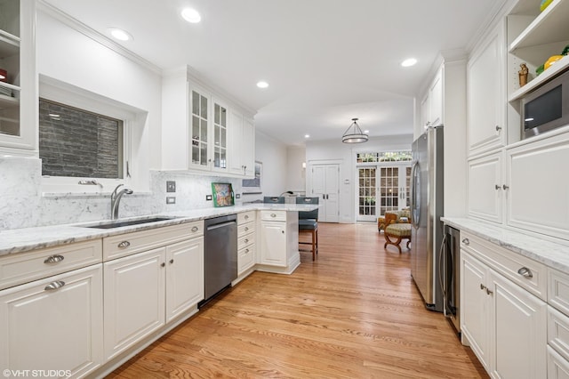 2535 N Burling St, Chicago, IL 60614 - kitchen featuring appliances with stainless steel finishes, a sink, light wood-style floors, white cabinets, and recessed lighting