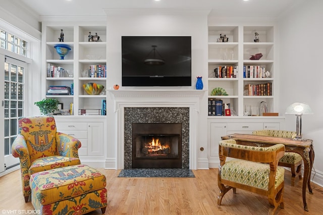 2535 N Burling St, Chicago, IL 60614 - living area featuring crown molding, a fireplace with flush hearth, wood finished floors, and built in shelves