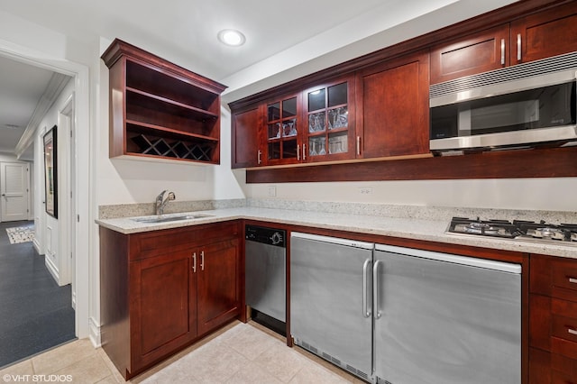 2535 N Burling St, Chicago, IL 60614 - kitchen featuring a sink, appliances with stainless steel finishes, light stone countertops, reddish brown cabinets, and recessed lighting