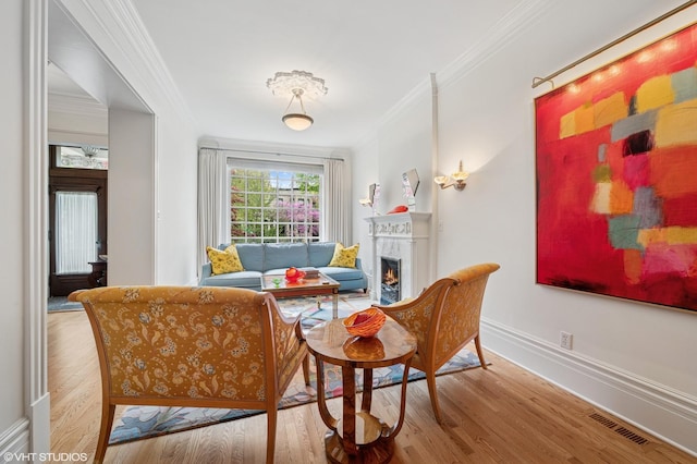 2535 N Burling St, Chicago, IL 60614 - sitting room with ornamental molding, wood finished floors, a lit fireplace, and baseboards