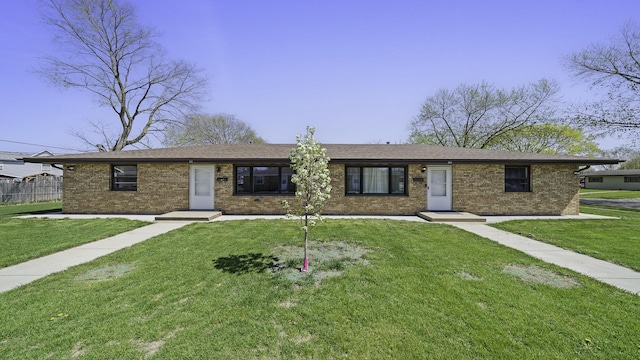 ranch-style home with a front yard and brick siding