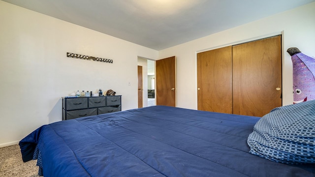 bedroom with baseboards, carpet, and a closet