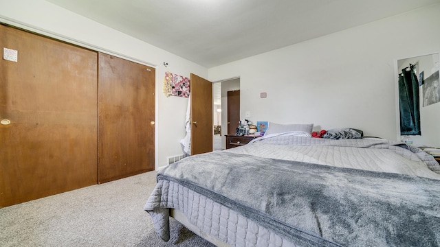 carpeted bedroom featuring a closet and visible vents