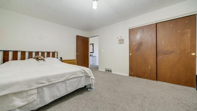 bedroom with carpet floors, baseboards, a closet, and visible vents