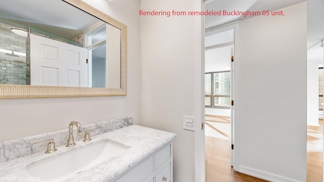 bathroom featuring tiled shower, wood finished floors, and vanity